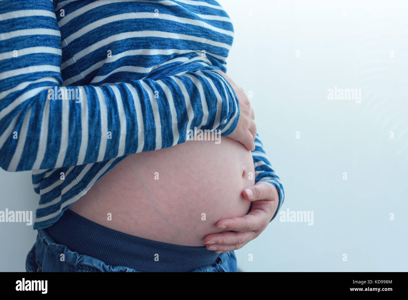 Schwangere Frau berühren und reiben ihren Bauch, Mutter streichelte und anregende Bauch, nach kaukasischen Frauen im fünften Monat oder 20 erste Woche von Stockfoto