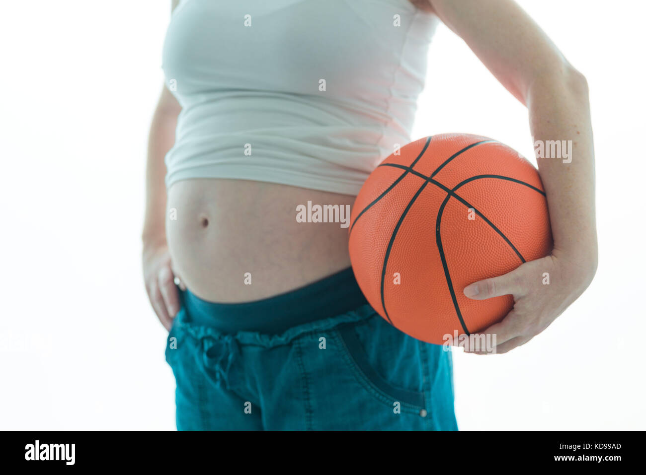 Schwangere Frau mit Basketball auf weißem Hintergrund Stockfoto