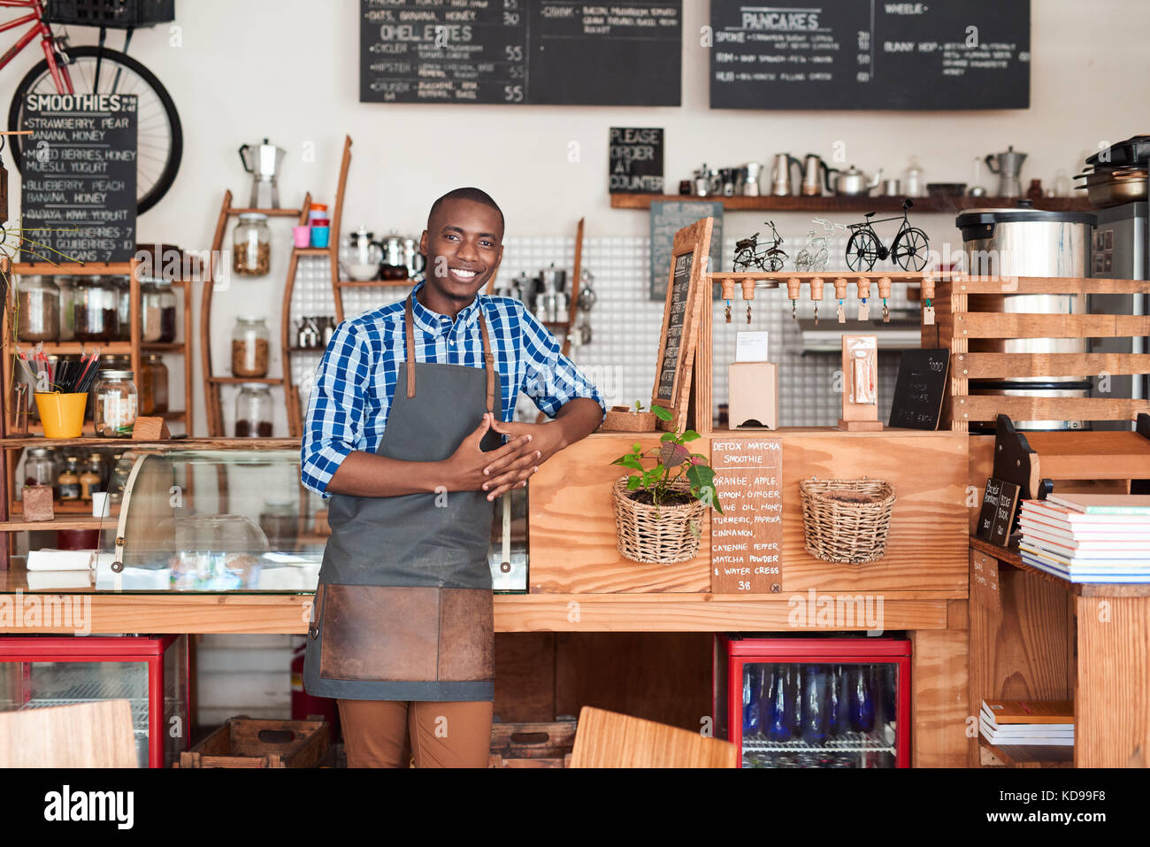Lächelnden jungen afrikanischen Barista stützte sich auf ein cafe Zähler Stockfoto