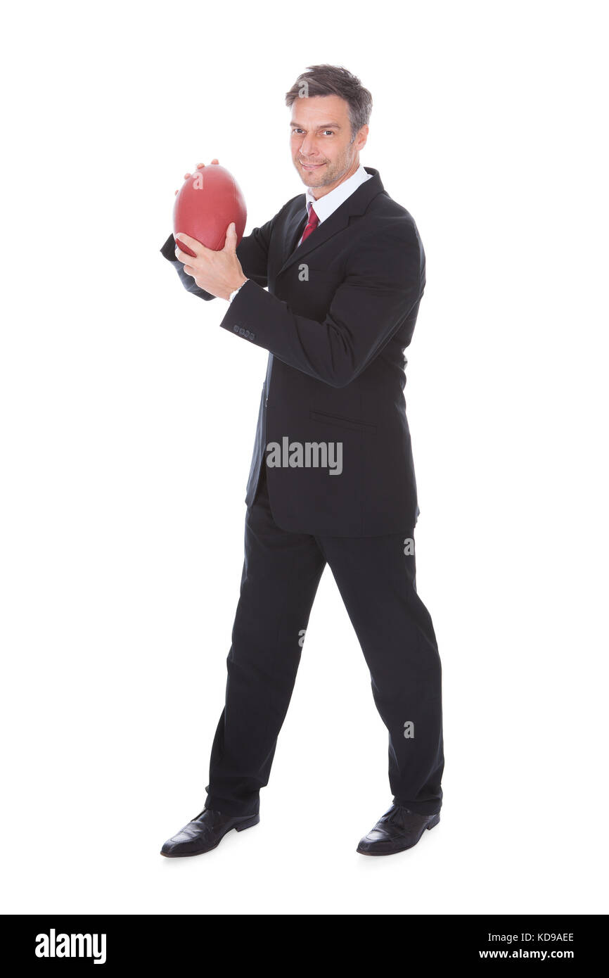 Portrait von Reifen Geschäftsmann Holding rugby ball auf weißem Hintergrund Stockfoto