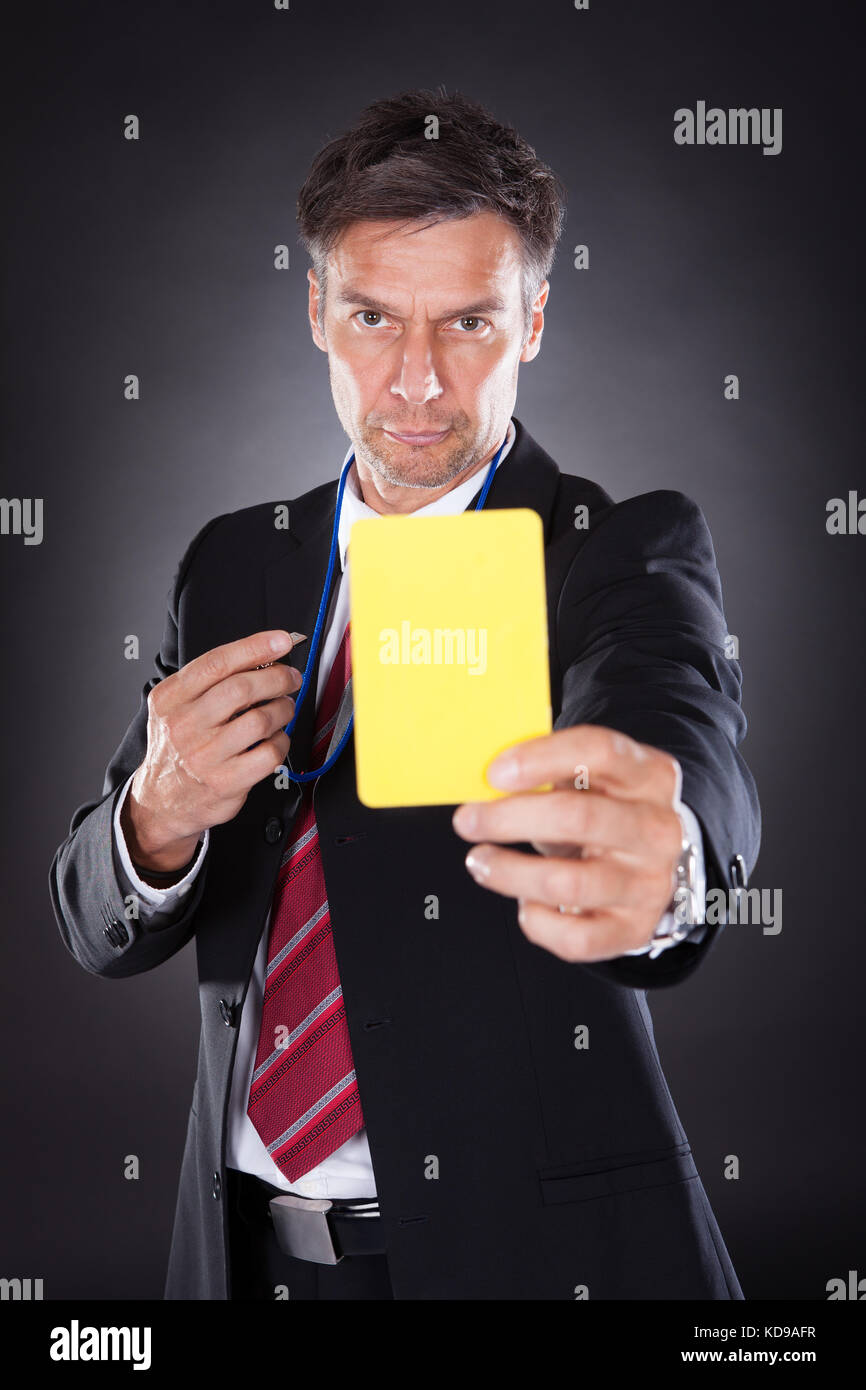 Porträt eines reifen Geschäftsmann, gelbe Karte, schwarzer Hintergrund Stockfoto