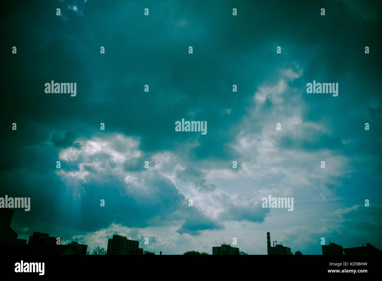Mystische bewölkter Himmel über der Stadt Silhouette Stockfoto