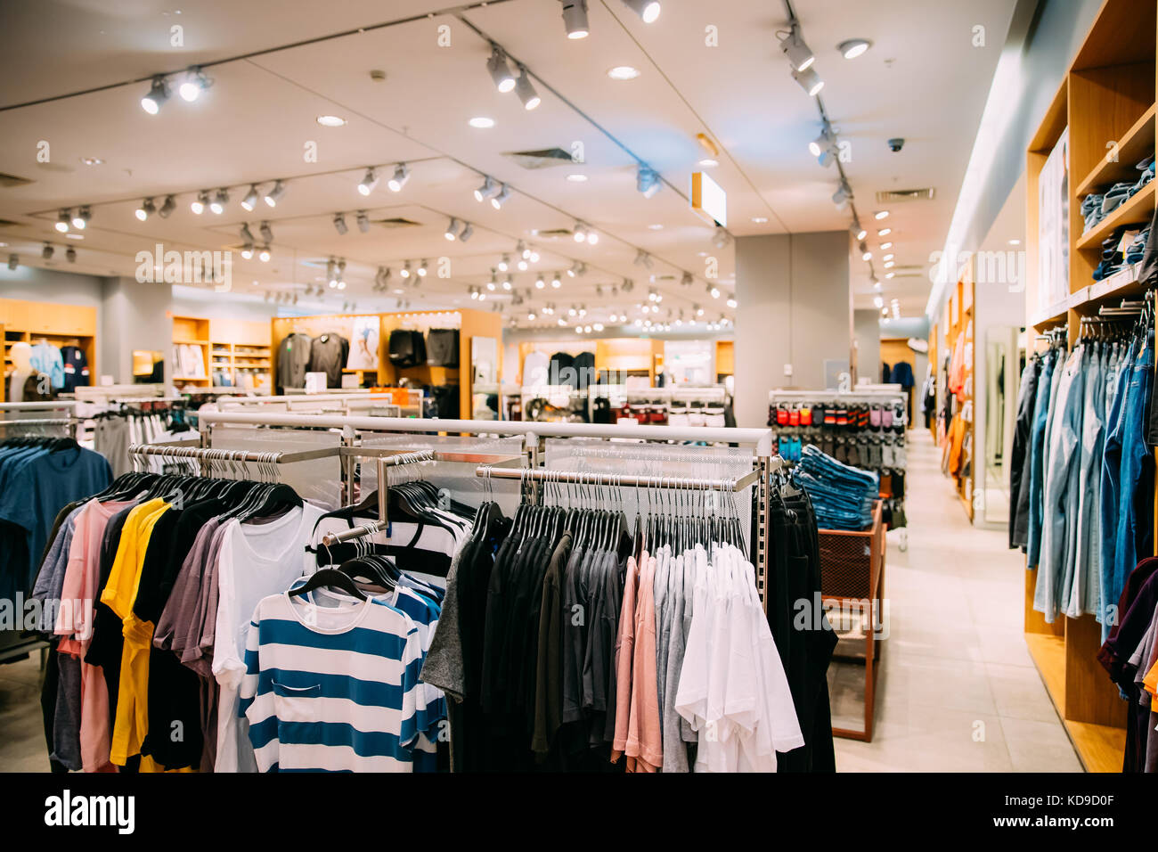 Bunte helle Kleidung in den Regalen und Kleiderbügel im Store im Einkaufszentrum. Stockfoto
