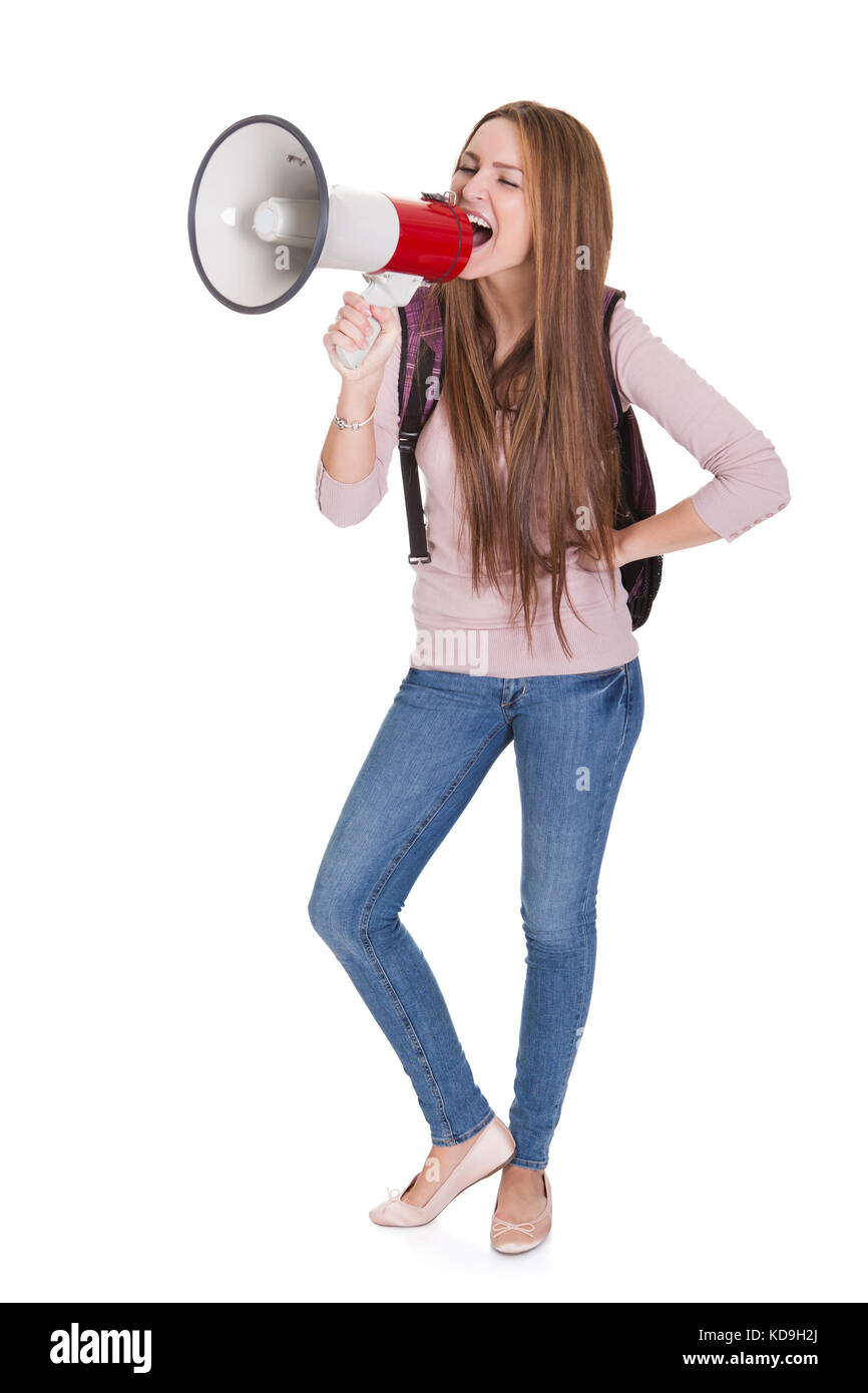 Junge Studentin Geschrei im Megaphon Over White Background Stockfoto