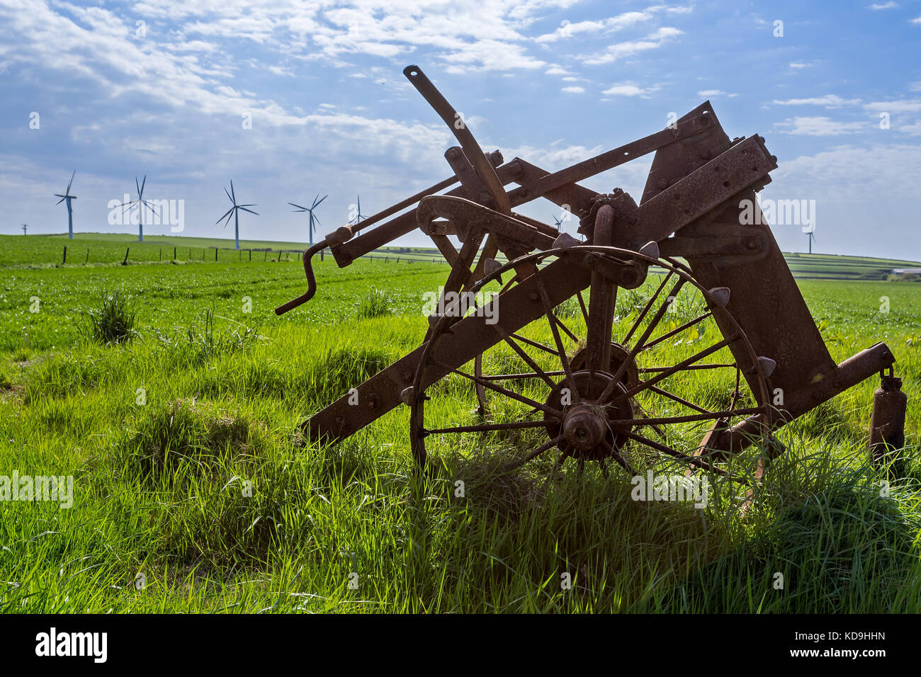 Alte und neue Technik - Windenergieanlagen und verlassenen Pflug Stockfoto