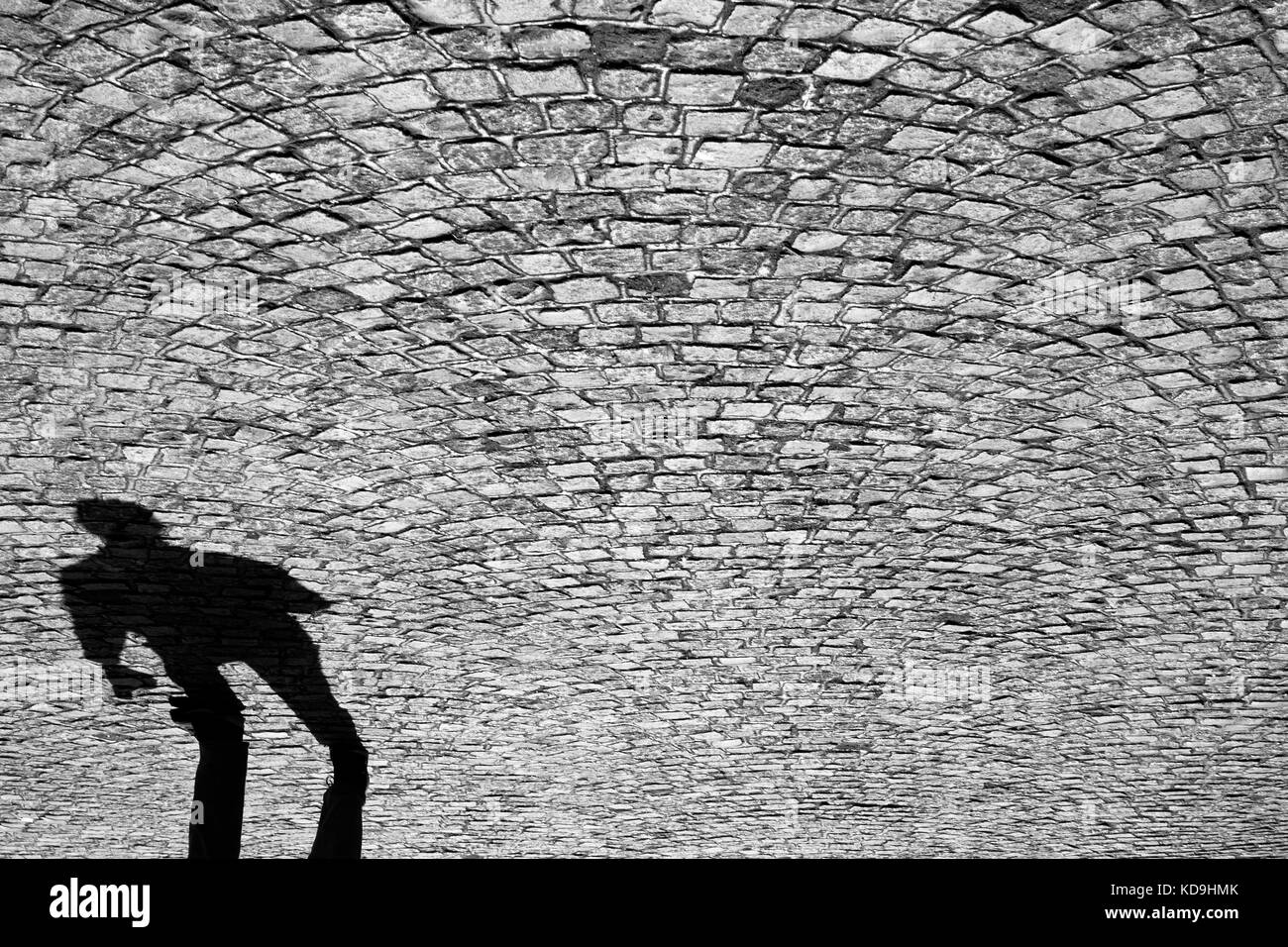 Verschwommene Schatten eines Menschen zu Fuß auf den alten gepflasterten Straße Stockfoto