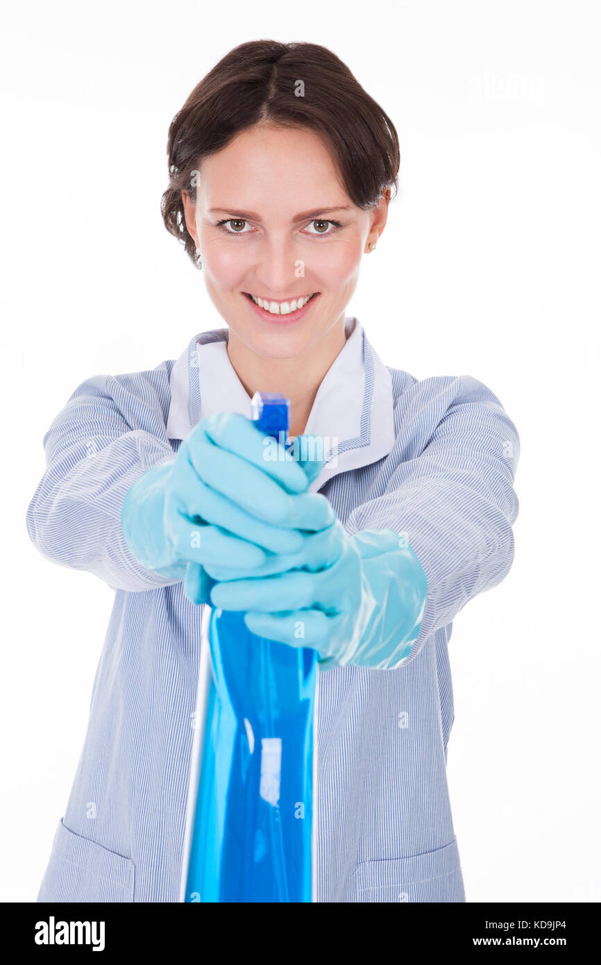 Lächelnde Frau in Uniform holding Reinigungsflüssigkeit und Spritzen Stockfoto