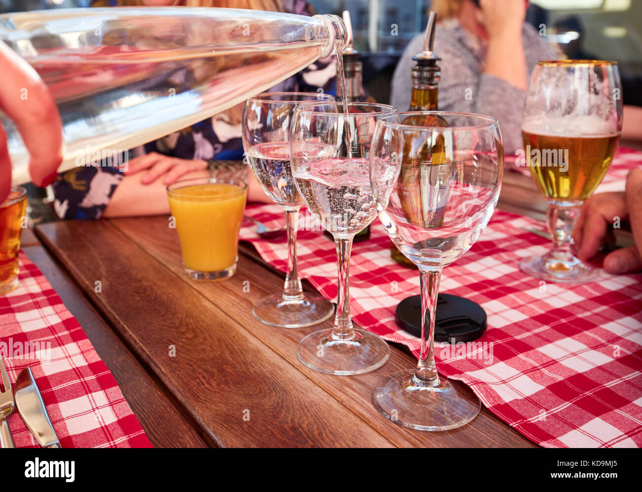 Kellner gießen Mineralwasser aus der Flasche in ein Glas. Stockfoto