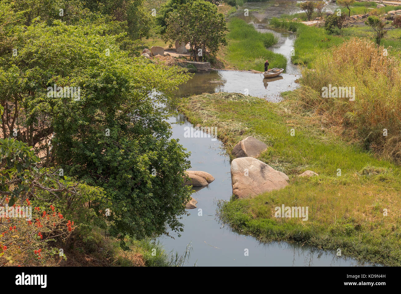 Fließende Fluss mit Felsen, Vegetation, Fischer und Boot in Afrika. lubango. Angola. Stockfoto