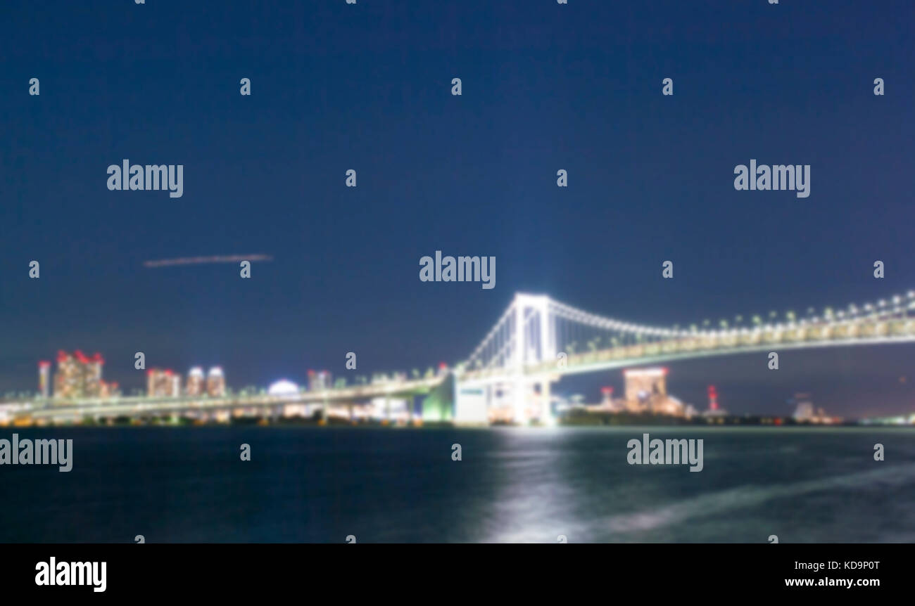 Foto von Tokio Skyline mit den beleuchteten Rainbow Bridge bei Nacht verwischt. Stockfoto