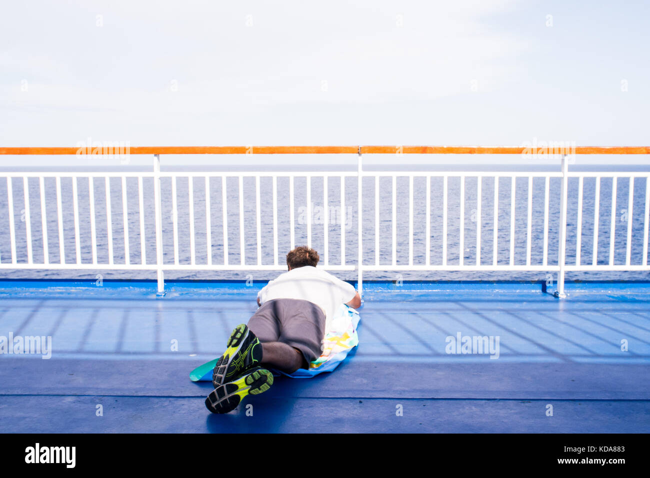 Ein Mann, der auf dem Deck eines Schiffes sieht am Horizont beim Segeln auf dem Mittelmeer Stockfoto