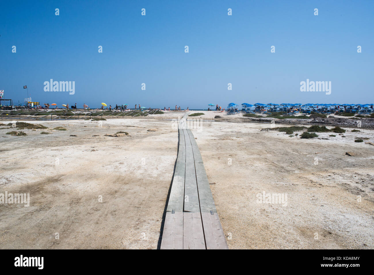Blick auf den Strand von le Saline gegen den klaren, blauen Himmel mit einer hölzernen Plattform Pfad, der zum Strand überquert Stockfoto
