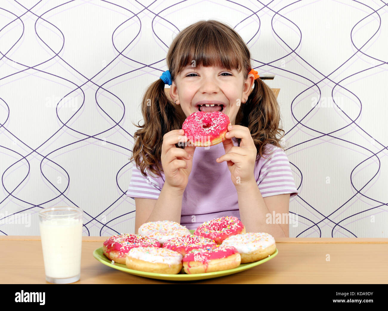 Gerne kleine Mädchen donuts Essen Stockfoto
