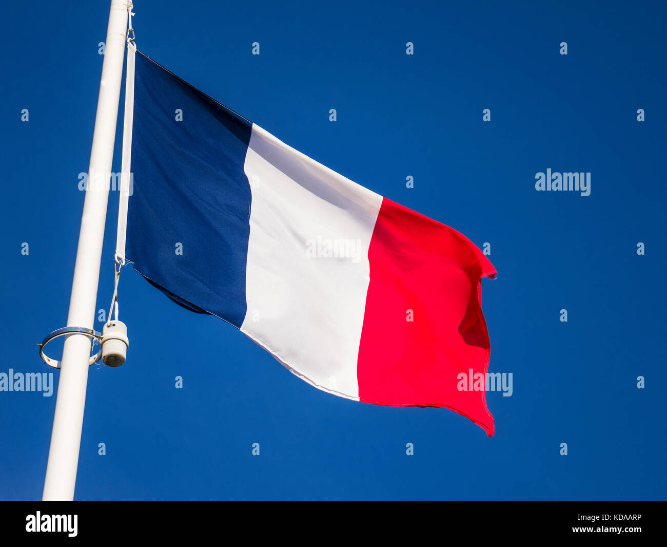 Französische Trikolore Flagge die Nationalflagge Frankreichs, die in der fließt Wind gegen einen ununterbrochenen tiefblauen Himmel Stockfoto
