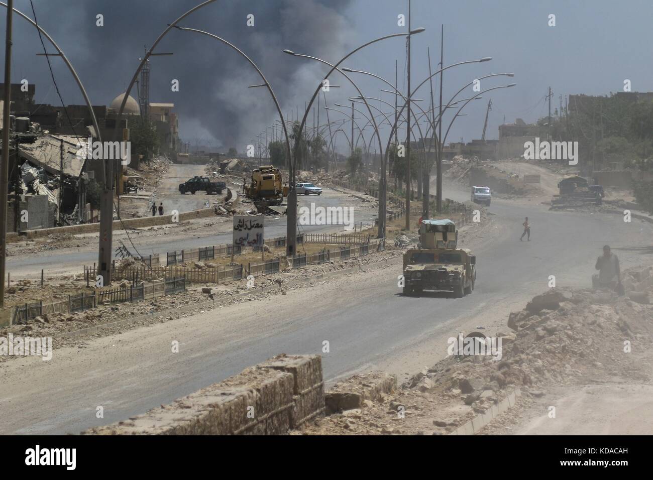 Eine irakische Armee humvee Laufwerke über einen irakischen Nachbarschaft vor kurzem befreit von Isis Extremisten Juni 7, 2017 in Mosul, Irak. Stockfoto