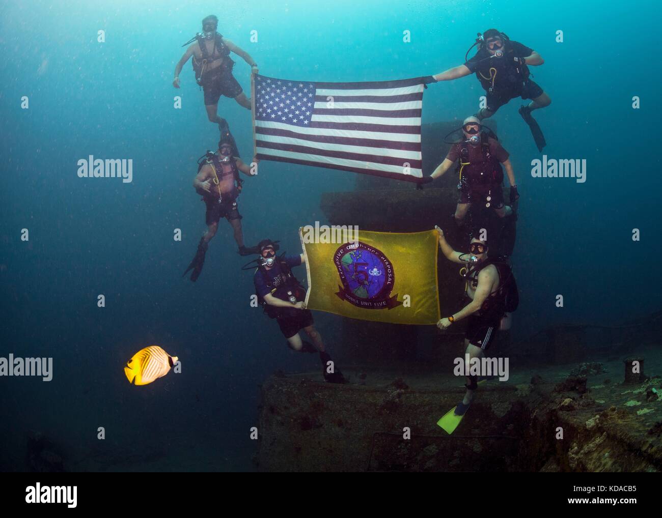 U.s. navy Matrosen halten die amerikanische Flagge und ihre Einheiten Flagge beim Tauchen an der amerikanischen Tankerunglück in der Nähe von Naval Base guam Juni 21, 2017 in Apra Harbor, Guam. Die amerikanischen Tanker ist eine versunkene konkrete Lastkahn, der während des Zweiten Weltkrieges zu transportieren war Stockfoto