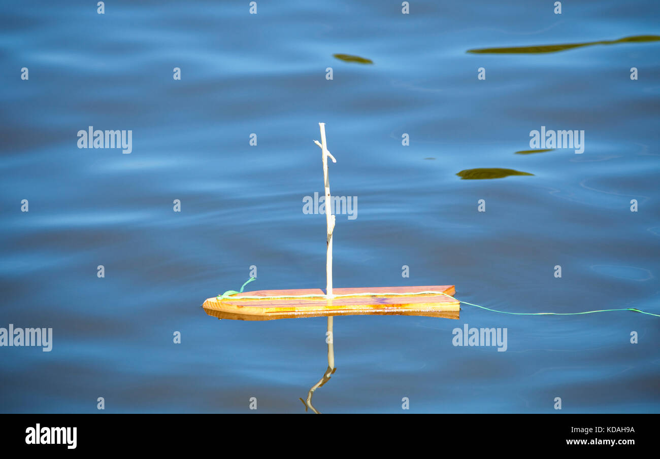 Holzspielzeug Segelboot ohne Segel auf dem See. Stockfoto