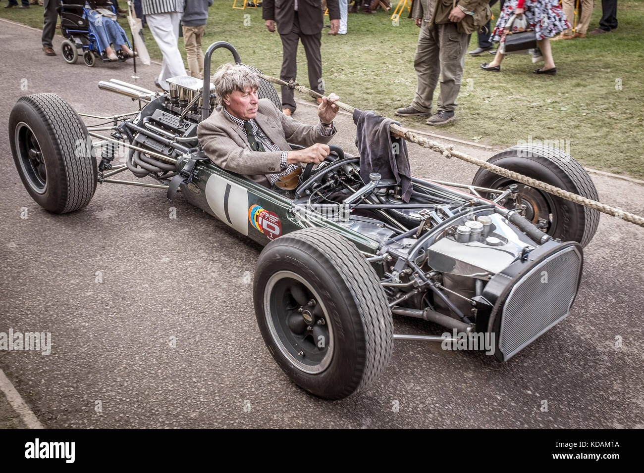 John Romano's 1964 Brabham-Climax BT11 wird mit fehlenden Karosserieblechen durch das Fahrerlager gezogen. Beim Goodwood Revival 2017, Sussex, UK. Trophäe „Glover“. Stockfoto