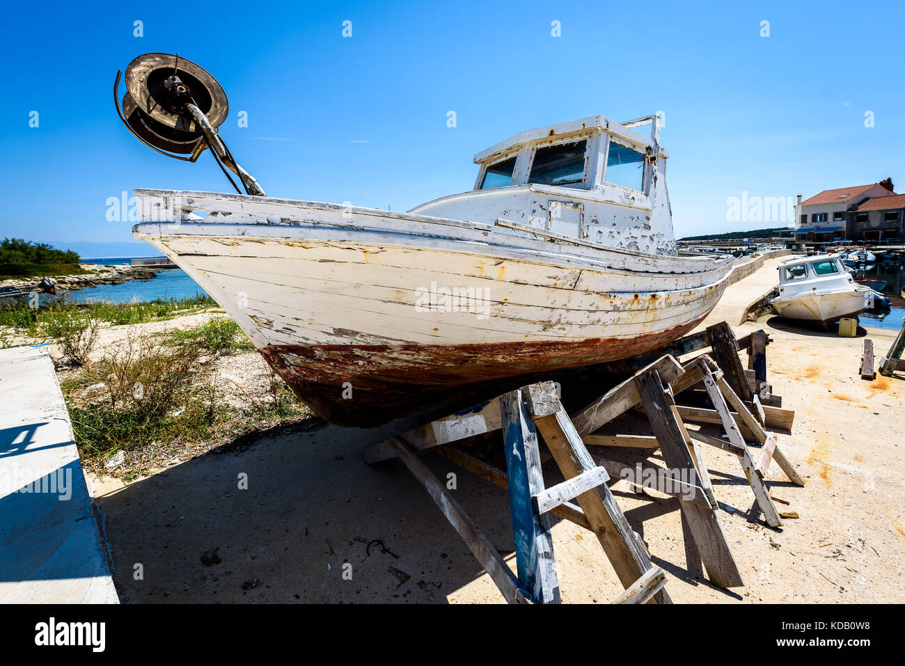 Reparatur und Restauration von alten hölzernen Angeln Schiff oder Boot. alte verwitterte Fischerboot montiert auf Holz- Buchsen für Dry Dock Renovierung und Reparatur mit Stockfoto