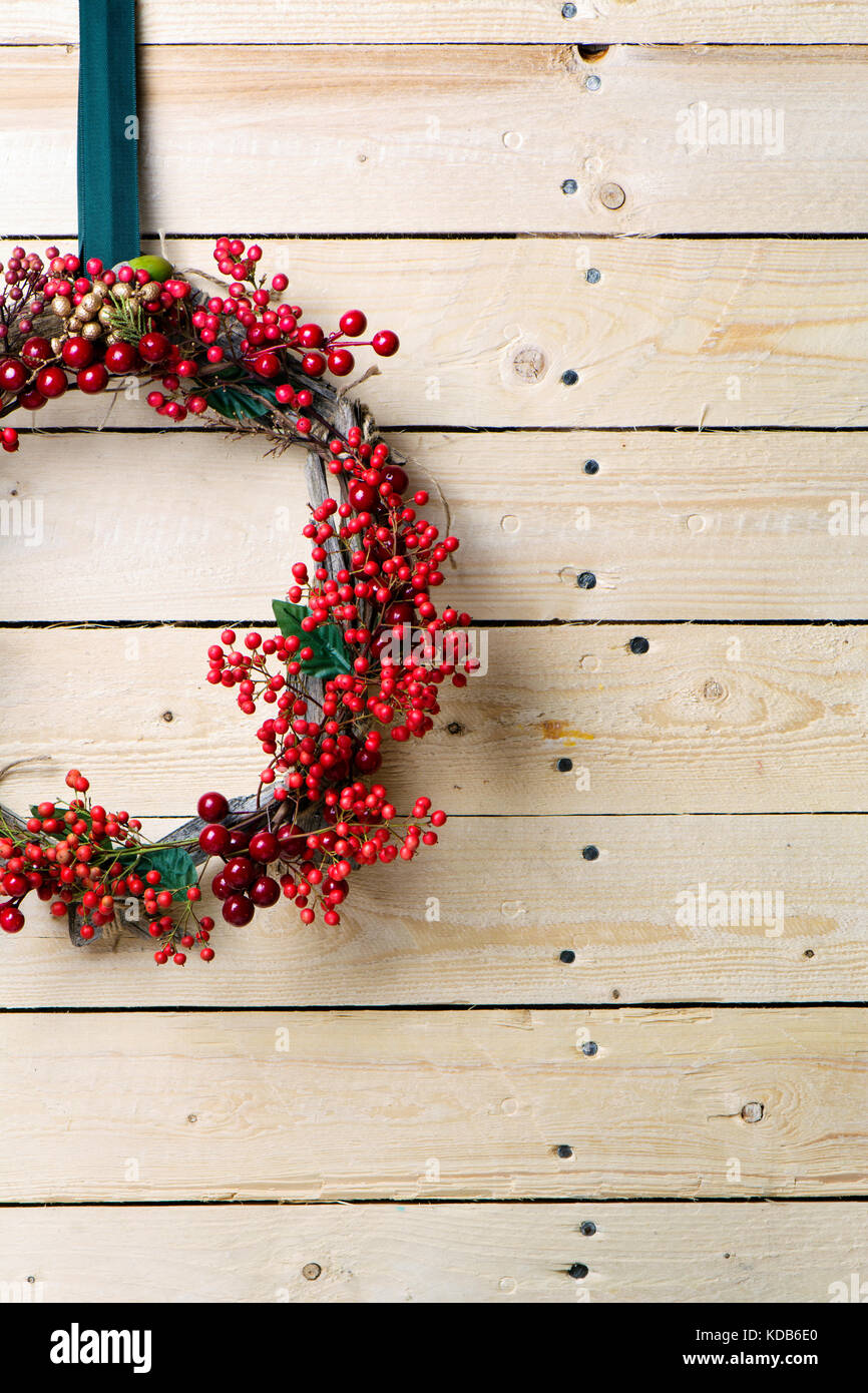 Weihnachten Kranz von Evergreen und Beeren auf hölzernen Hintergrund. Natürliche nandian Netzwerk und rustikalem Holz Krone Stockfoto