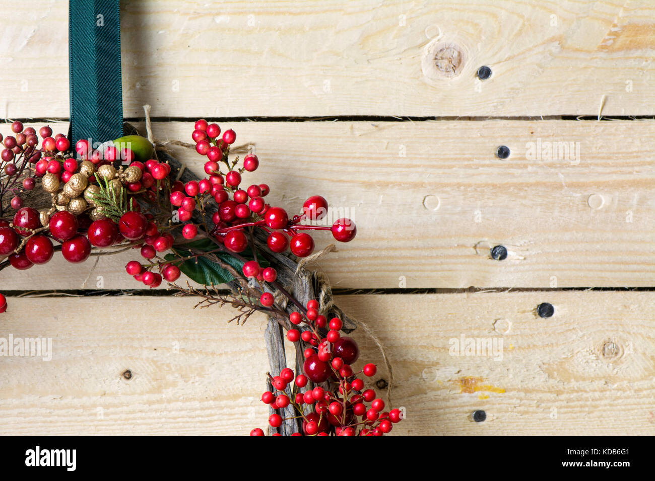 Weihnachten Kranz detail von Evergreen und Beeren auf hölzernen Hintergrund. Natürliche nandian Netzwerk und rustikalem Holz Krone Stockfoto