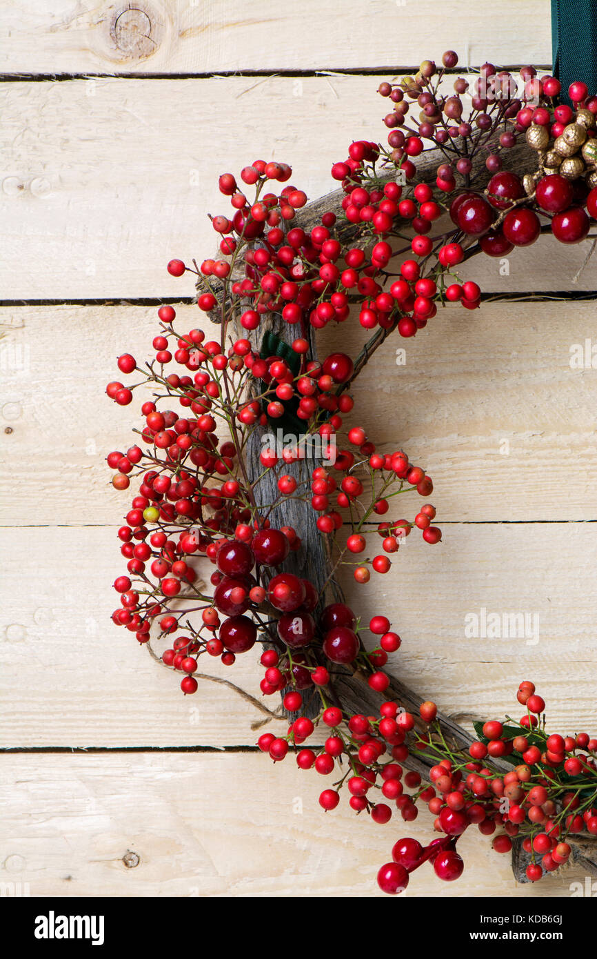 Weihnachten Kranz detail von Evergreen und Beeren auf hölzernen Hintergrund. Natürliche nandian Netzwerk und rustikalem Holz Krone Stockfoto