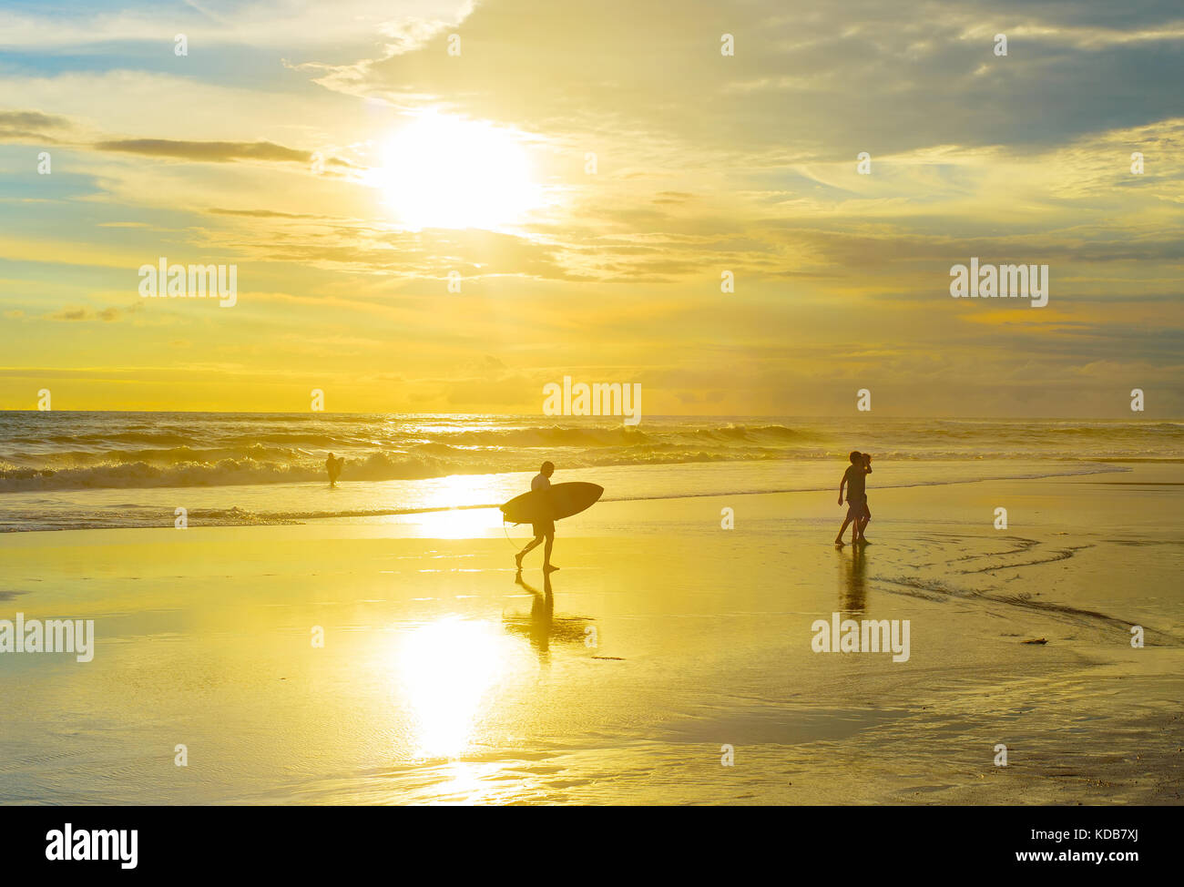 Surfer gehen am Strand mit Surfbrett bei Sonnenuntergang. die Insel Bali, Indonesien Stockfoto