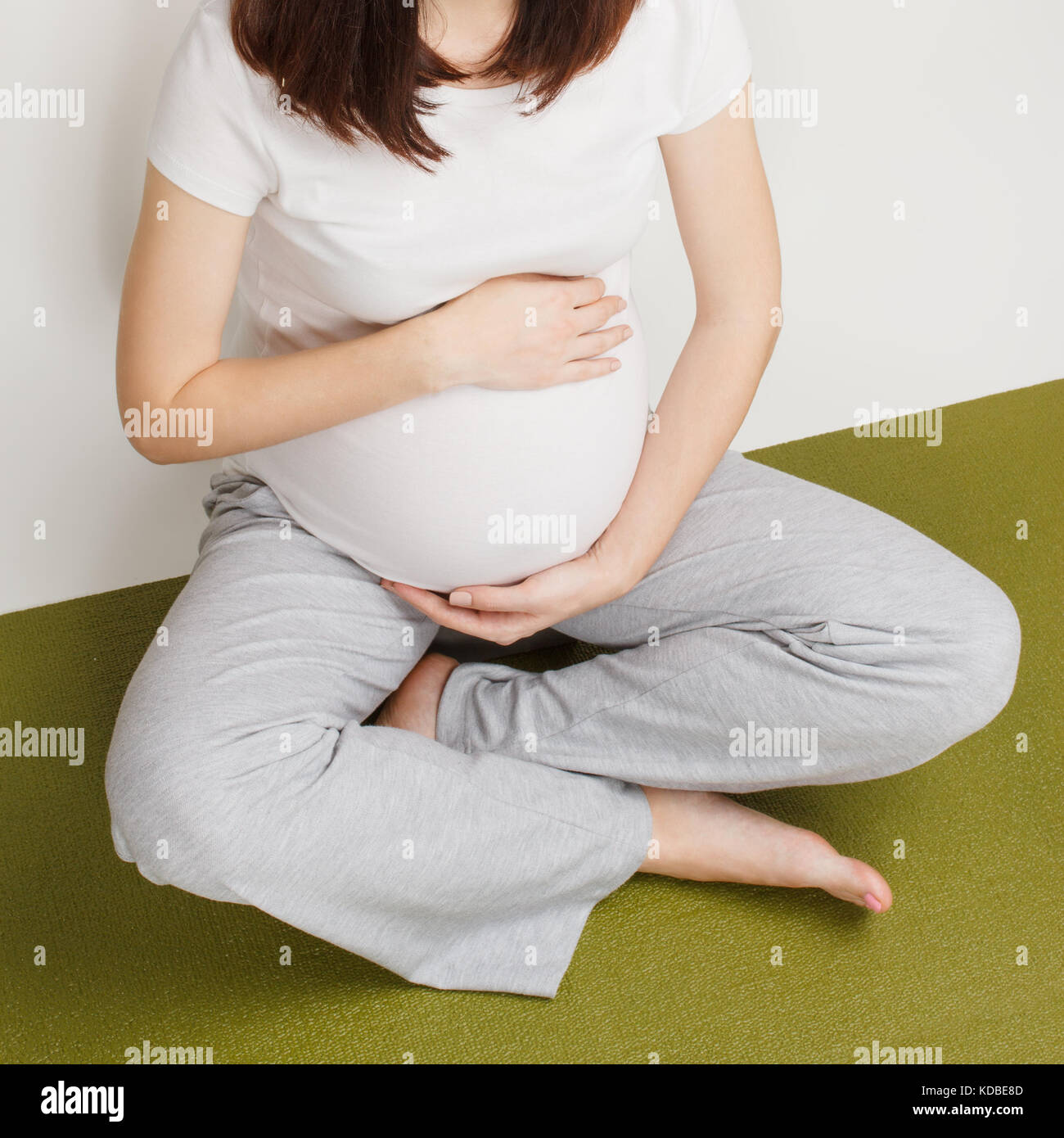 Schwangere Frau im Lotussitz sitzen Stockfoto
