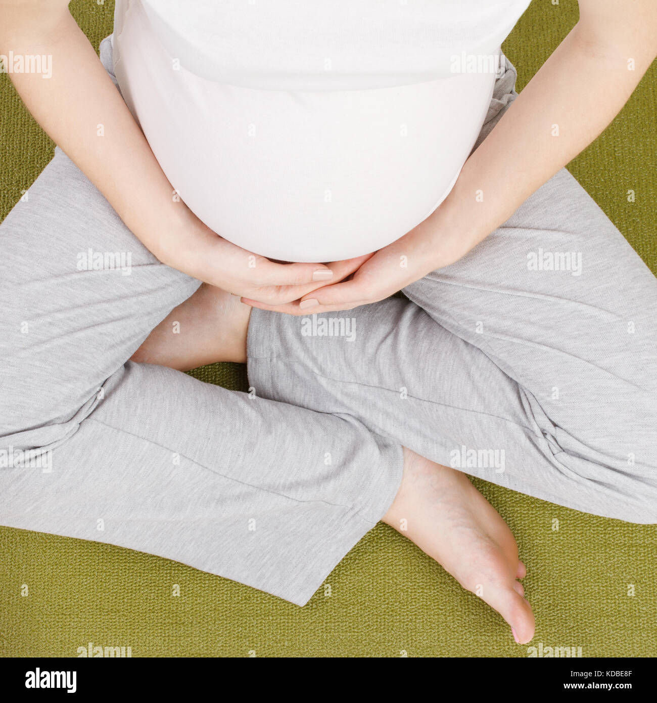Schwangere Frau im Lotus Position Stockfoto