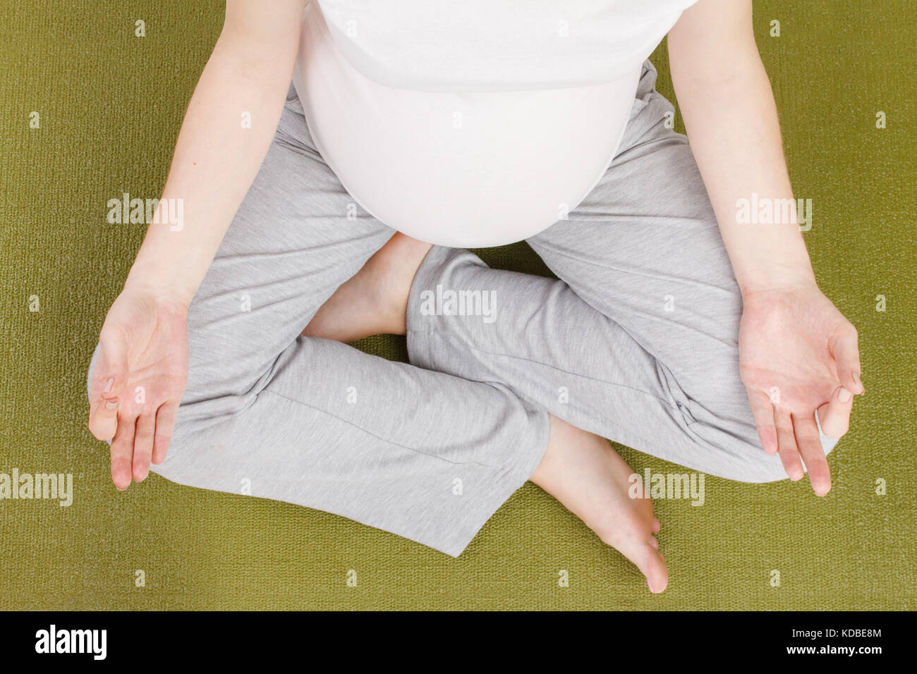 Blick von oben auf die schwangere Frau in Lotus Position Stockfoto