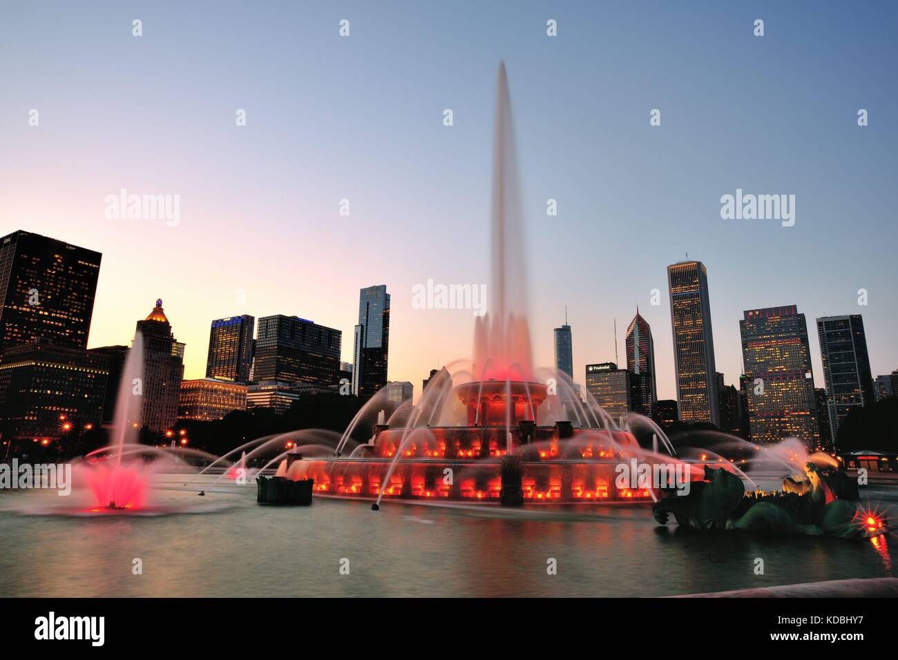 Mit einem Teil der Skyline von Chicago als Hintergrund Buckingham Fountain eine bunte Anzeige in der Dämmerung macht. Chicago, Illinois, USA. Stockfoto