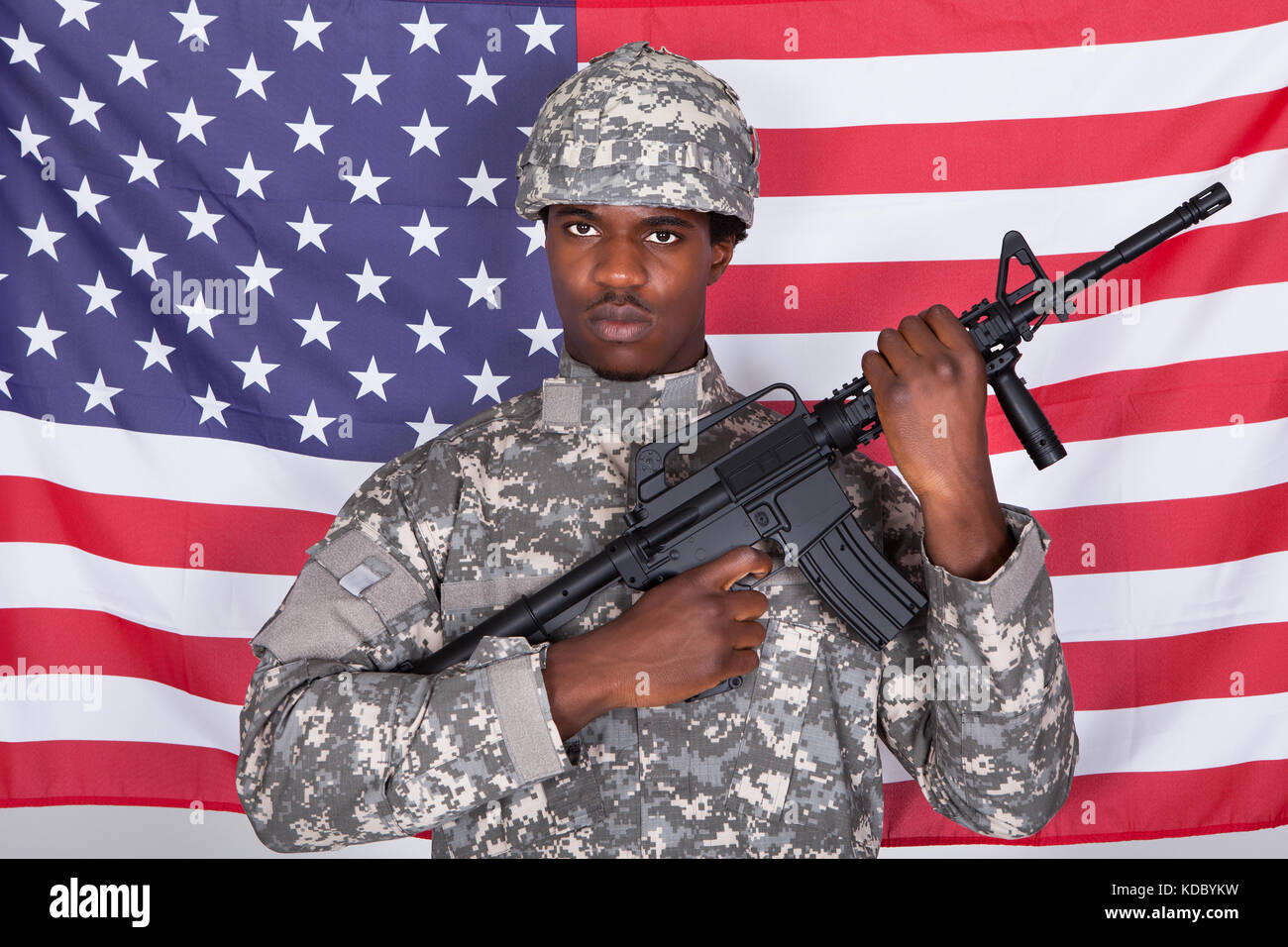 Afrikanische amerikanische Soldat stehend mit Gewehr stand vor der US Flag Stockfoto