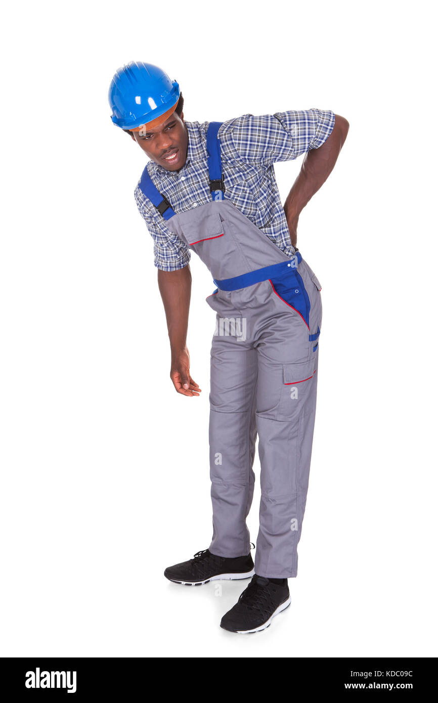 Junge afrikanische Handwerker mit Rückenschmerzen Isolated Over White Background Stockfoto