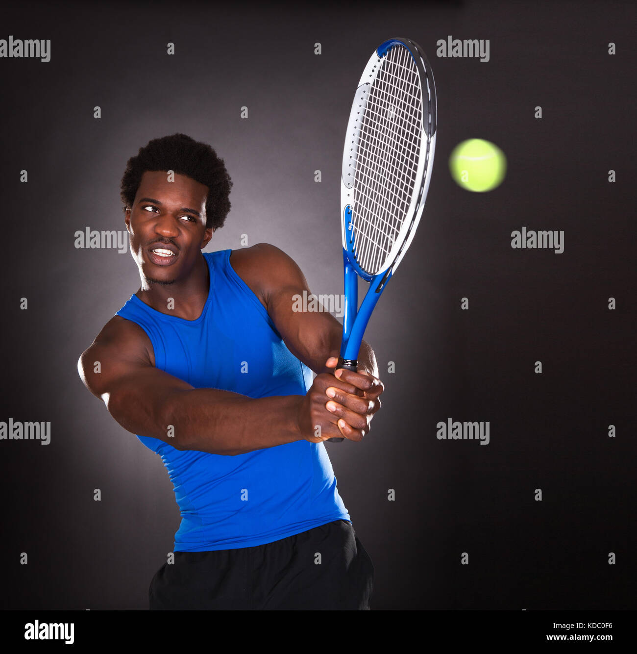 Junge Afrikaner Tennisspielen mit Tennisschläger Stockfoto