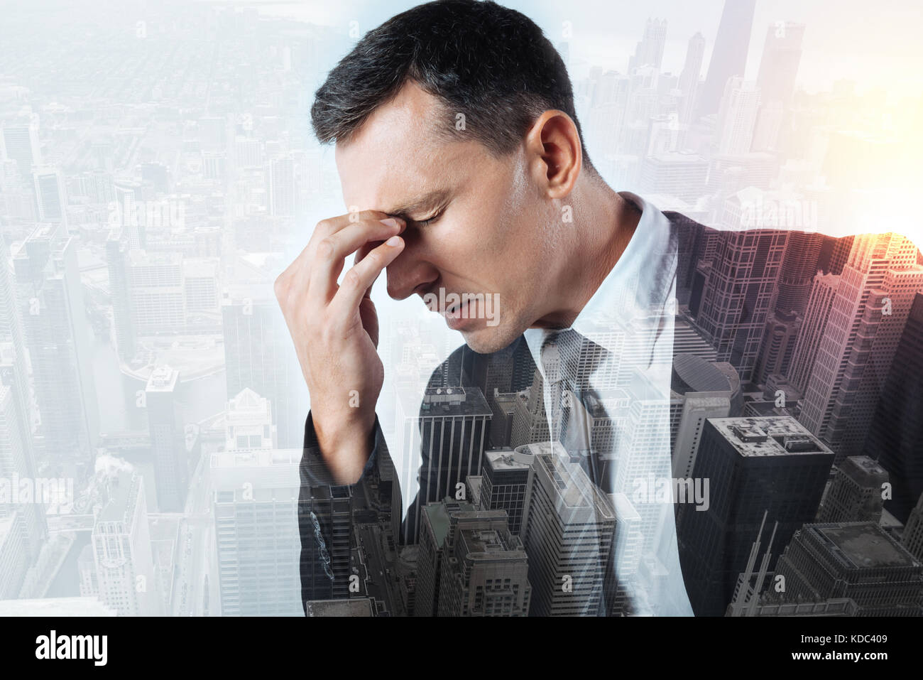 Ernsthafte Büroangestellter schreckliche Kopfschmerzen leiden. Stockfoto