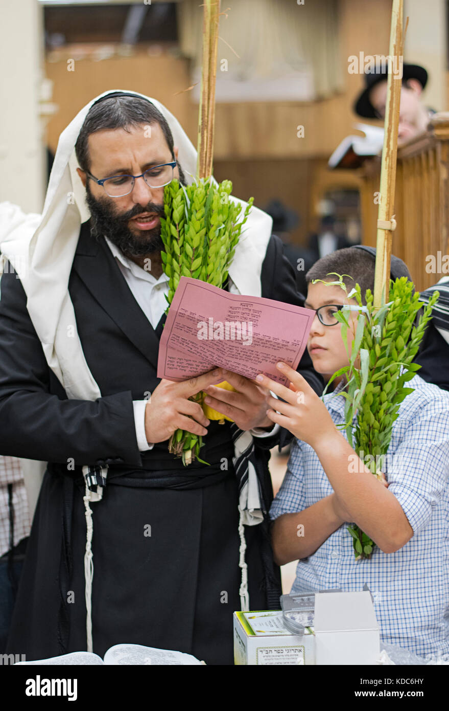 Vater und Sohn beten gemeinsam an Sukkot auf eine Synagoge in Brooklyn, New York Stockfoto