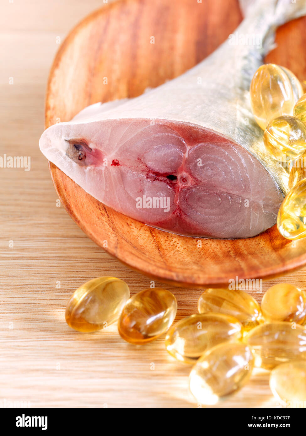 Nahaufnahme frisch schneiden Makrele in Löffel aus Holz mit Fischöl kapseln. Die Ergänzung hoher Vitamin E, Omega 3, DHA und EPA. selektive Fokus Flach Stockfoto