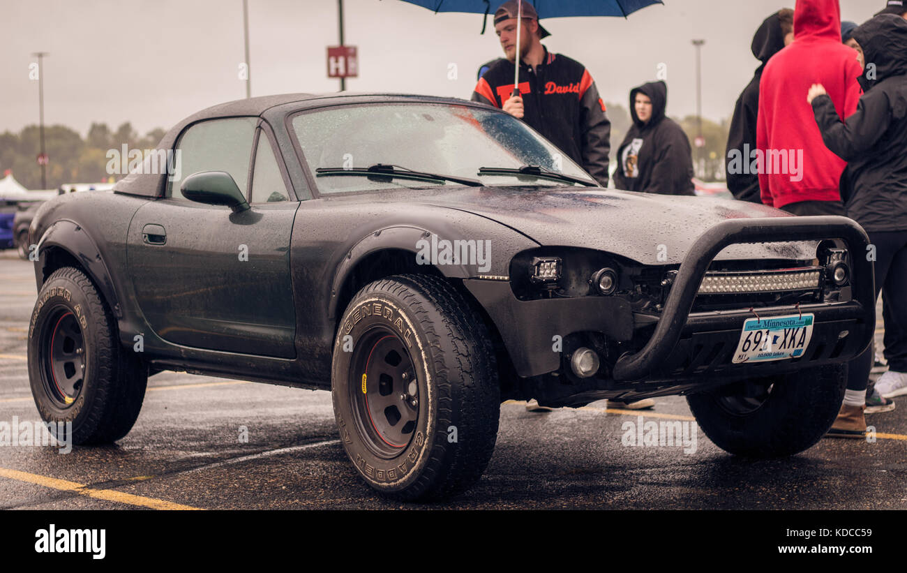 Menschen beobachten einer angehobenen Fahrzeug an einem Auto erfüllen. Stockfoto