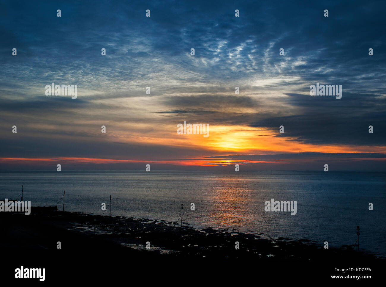 Dramatischer Sonnenuntergang in einem ruhigen Meer in Hunstanton in Norfolk, England Stockfoto