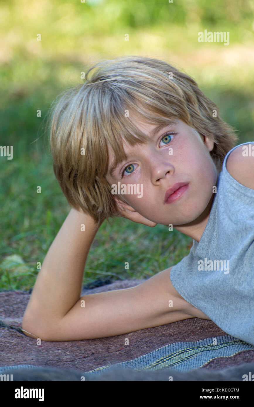 Porträt eines Jungen liegend, seinen Kopf auf seine Hand Stockfoto