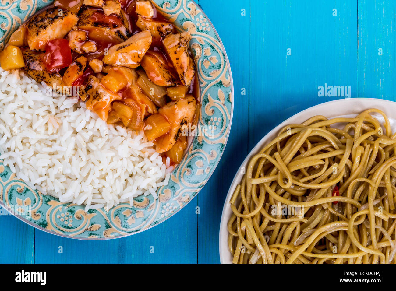 Kantonesischen Stil süß und sauer Huhn mit weissem Reis auf einem blauen Hintergrund aus Holz Stockfoto