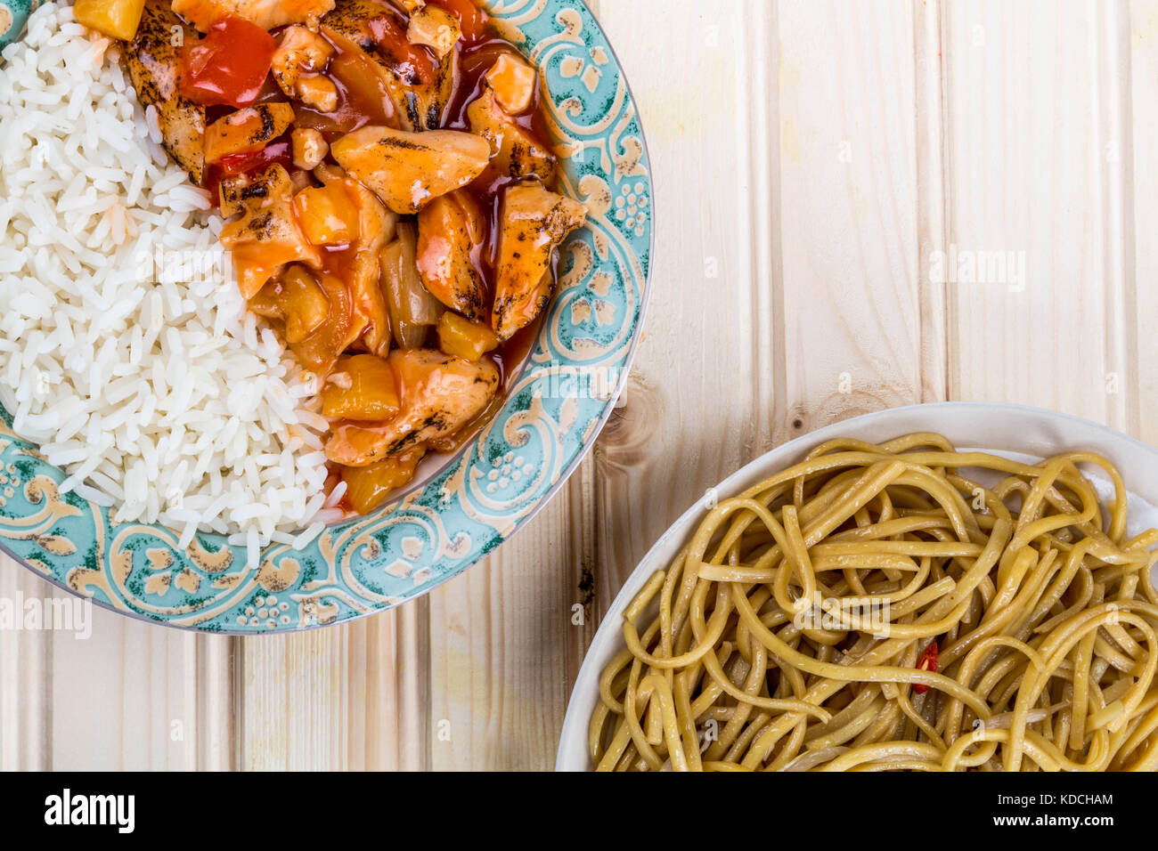 Kantonesischen Stil süß und sauer Huhn mit weissem Reis gegen einen hellen Hintergrund aus Kiefernholz Stockfoto