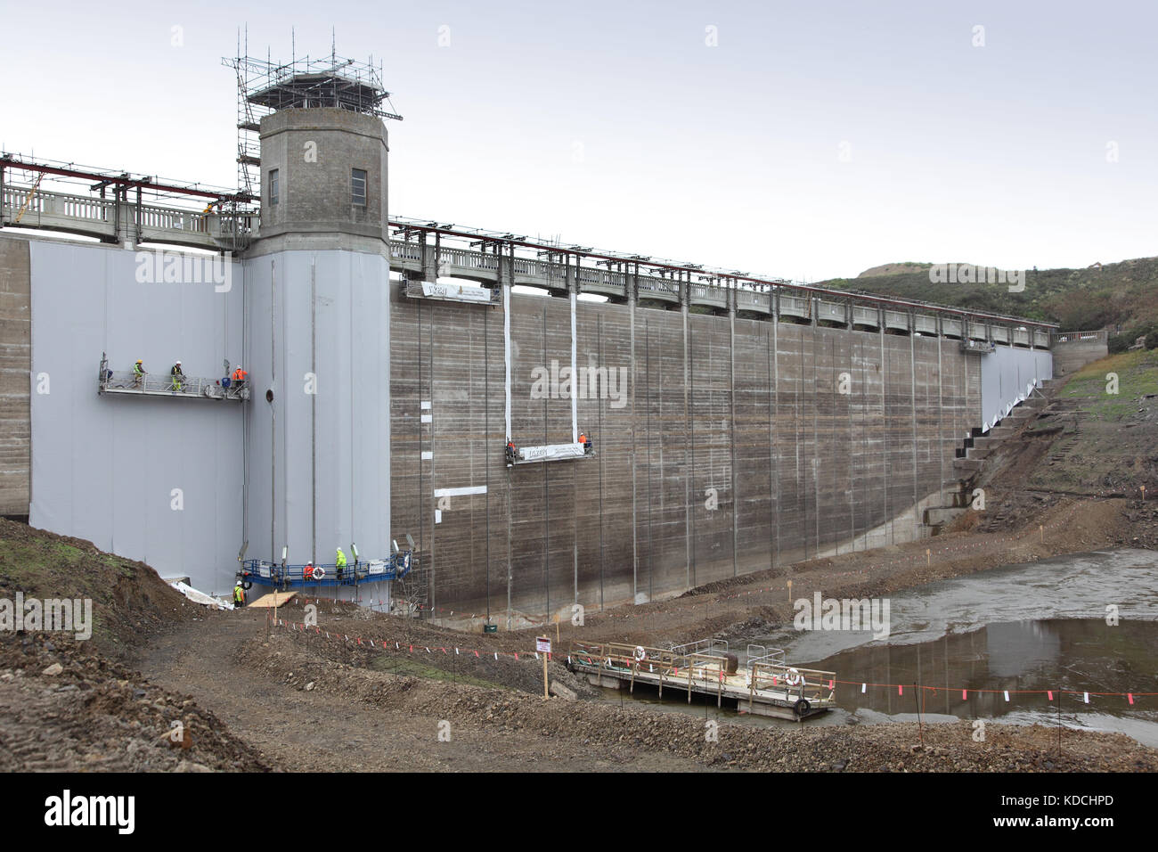 An der Innenseite des Staudamms Val de la Mare in Jersey, Großbritannien, wird eine Kunststoffmembran befestigt, um Alkali-Aggregatreaktion im Beton zu verhindern. Stockfoto