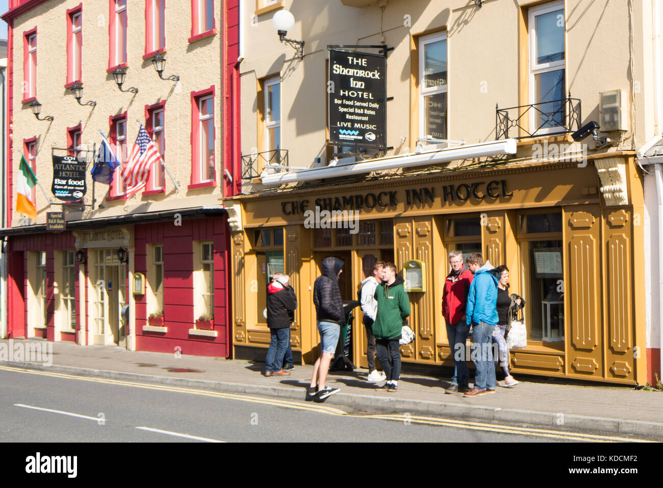 Touristen außerhalb des Shamrock Inn und Atlantic Hotels auf der Main Street von Lahinch in der Grafschaft Clare an der wilden Atlantikküste, an der Westküste von Irland Stockfoto
