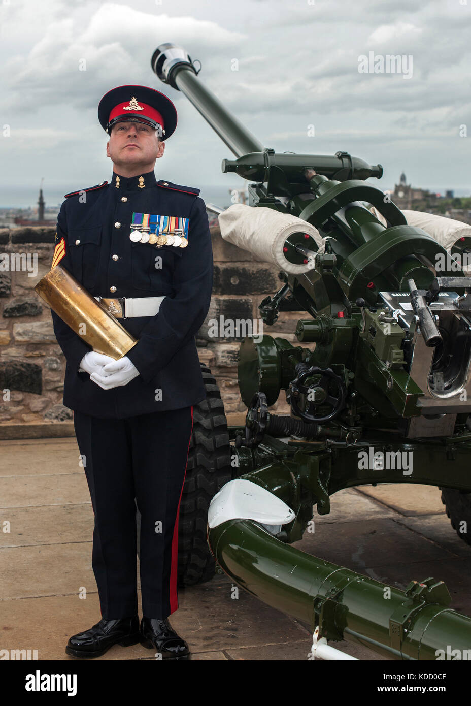 Bezirk Gunner Sergeant Dave Beveridge posiert mit leeren Schale nach dem Feuern die One o'clock Gun im Edinburgh Castle in Schottland. Stockfoto