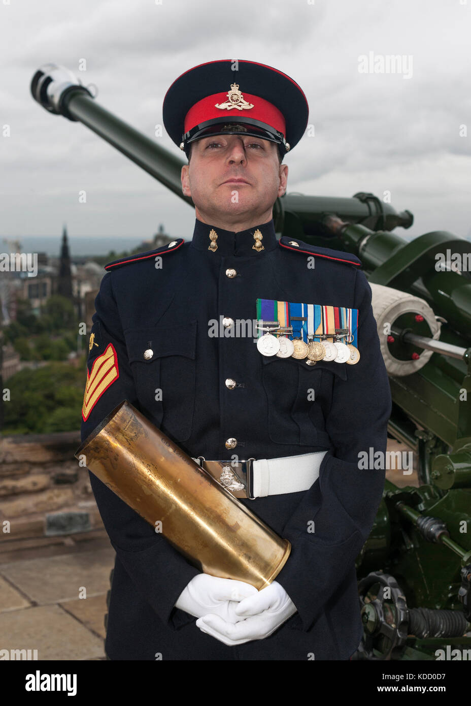 Bezirk Gunner Sergeant Dave Beveridge posiert mit leeren Schale nach dem Feuern die One o'clock Gun im Edinburgh Castle in Schottland. Stockfoto