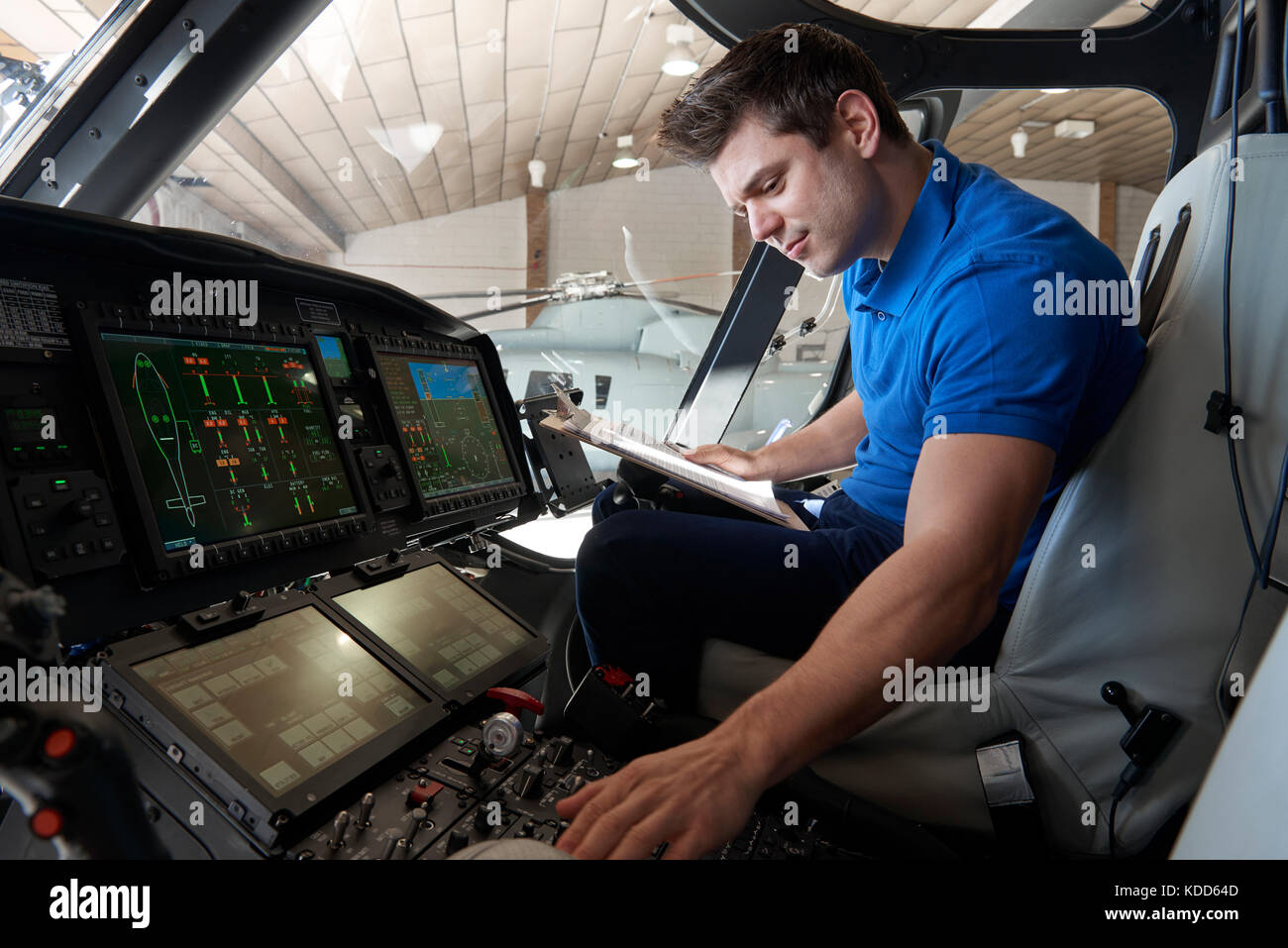 Männliche aero Ingenieur mit Zwischenablage in Helicopter Cockpit arbeiten Stockfoto