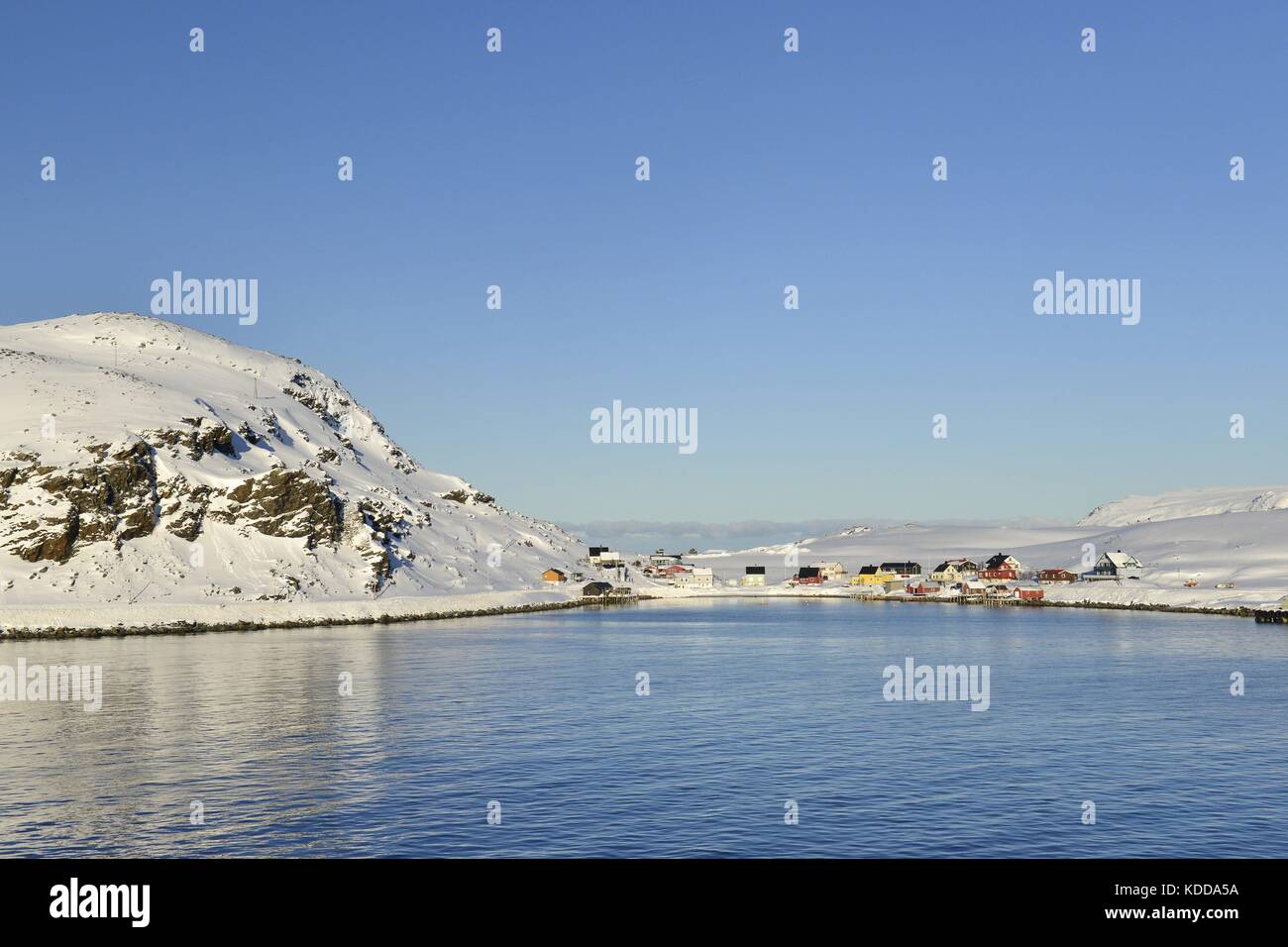 Mehrere Häuser der kleinen Stadt Havøysund direkt durch das blaue Wasser des Norwegischen See, 7 März 2017 | Verwendung weltweit Stockfoto