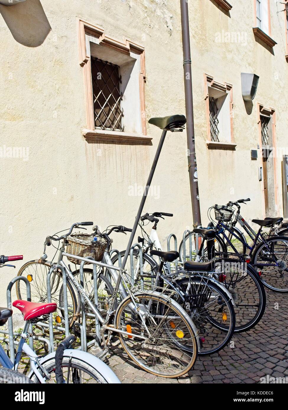 Brixen Trentino Alto Adige, Italia Brixen Südtirol Italien. Zeile der geparkten Fahrräder mit lustigen Fahrrad mit unmöglich Sattelstütze. Stockfoto