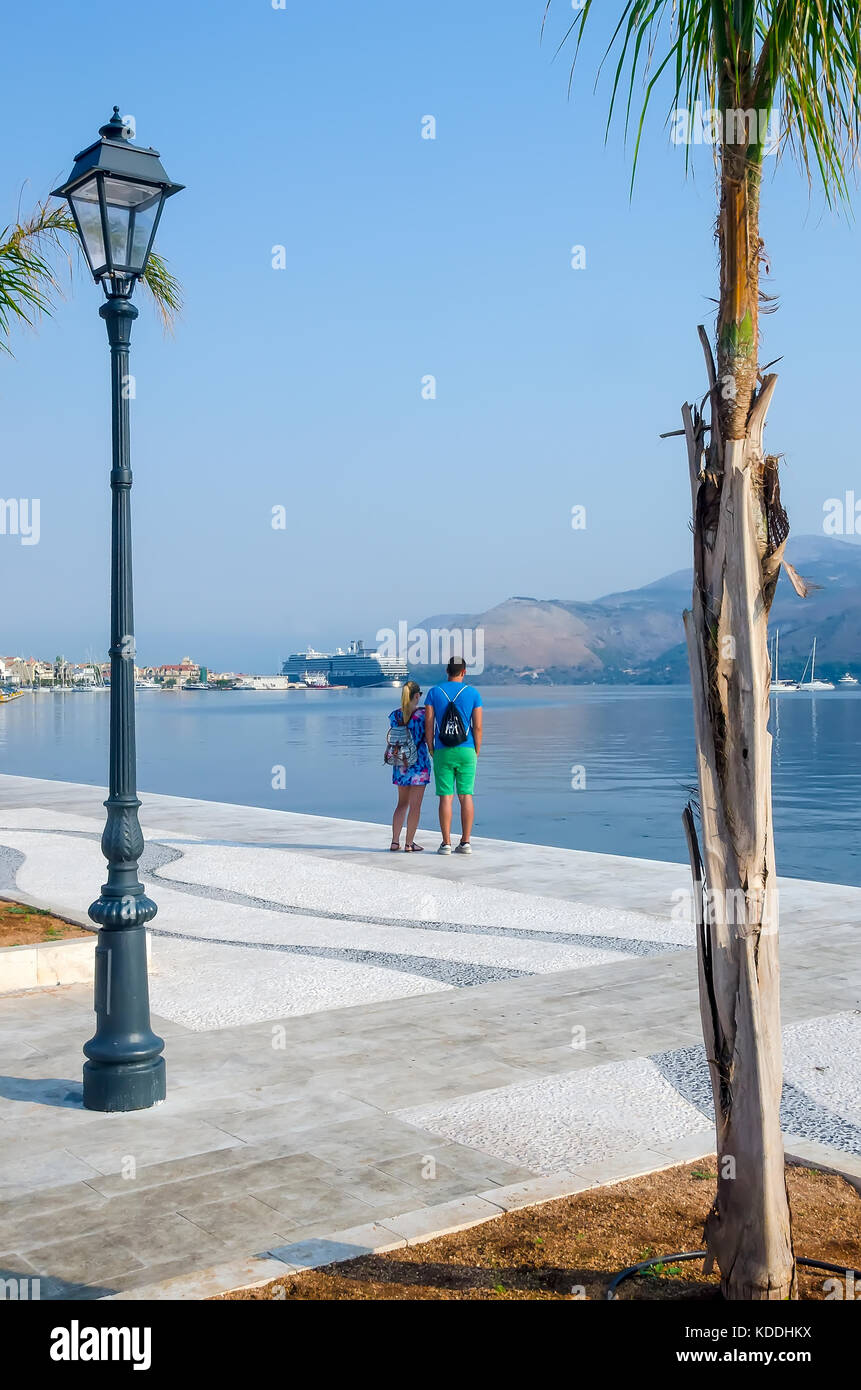 Argostoli Griechenland Paar an der Strandpromenade neben dem Hafen für Karettschildkröten, Kefalonia, Kefalonia, Ionische Inseln, Griechenland. Stockfoto